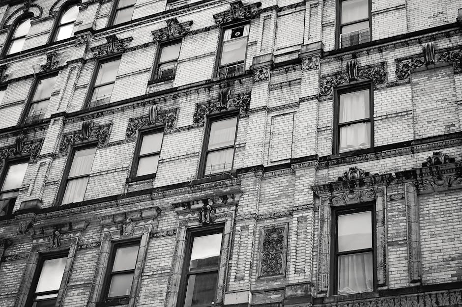 Black and white photo of an old urban brick building facade with detailed architecture.